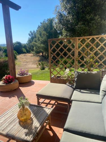 a patio with a couch and a table and a fence at Wild sud Sardinia 3 in Teulada