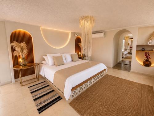 a bedroom with a large bed with a chandelier at Casa Elixir Boutique in Barranquilla