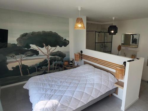 a bedroom with a bed with a painting on the wall at Les Suites du XV in Cap d'Agde