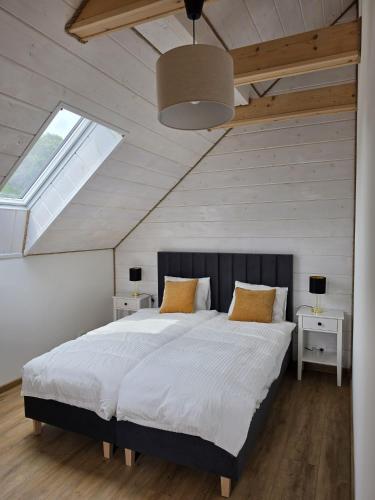 a bedroom with a large bed with a large window at Bieszczady Bóbrka 24 in Bóbrka
