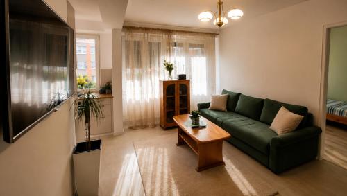 a living room with a green couch and a table at Apartament Okrzei in Lublin