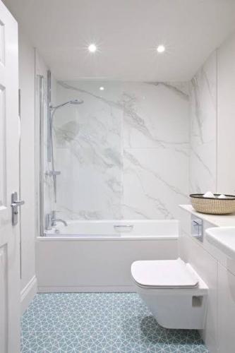 a white bathroom with a toilet and a shower at Charlie Hotel in Kakani