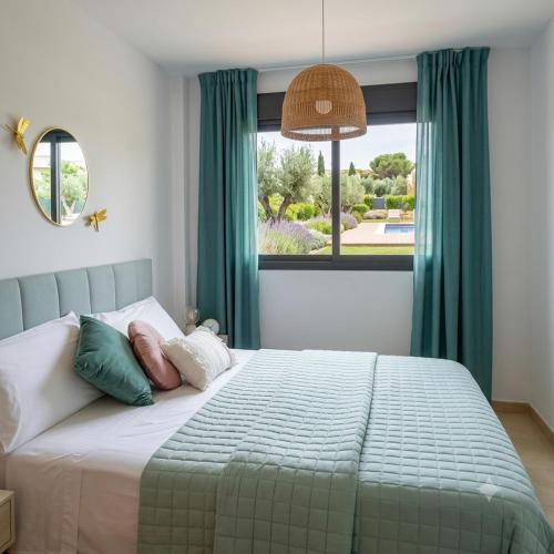 a bedroom with a bed with green curtains and a window at ILDA MENTa in Miami Platja