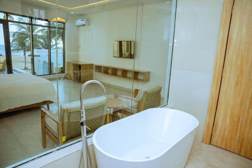 a bathroom with a bath tub and a bedroom at Atlantic Shores Resort in Igbolobi