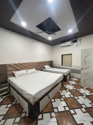 a bedroom with two beds in a room at Shreeji Nikunjdham in Vrindāvan