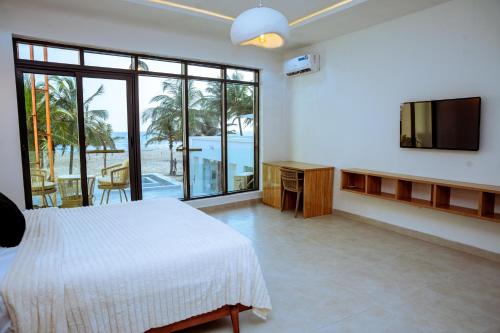a bedroom with a bed and a flat screen tv at Atlantic Shores Resort in Igbolobi