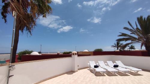 a group of white chairs sitting on top of a roof at Casa Girasoles terraza patio aire acondicionado in Corralejo