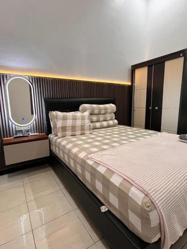 a bedroom with a large bed and a window at Emmir Homestay in Cilacap