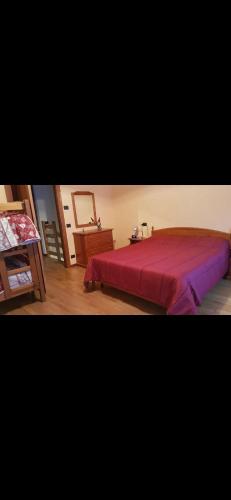ein Schlafzimmer mit einem großen Bett und einer roten Tagesdecke in der Unterkunft Chalet Laghetti in Schilpario