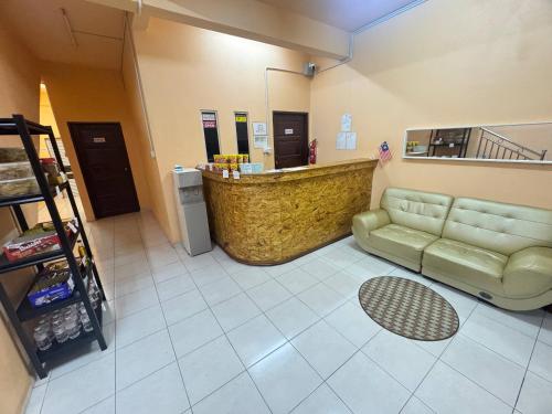 a waiting room with a couch and a counter at Hotel RS Inn in Rantau Panjang