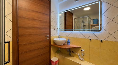 ein Badezimmer mit Waschbecken und Spiegel in der Unterkunft Residence Sciara Sciat in Foggia