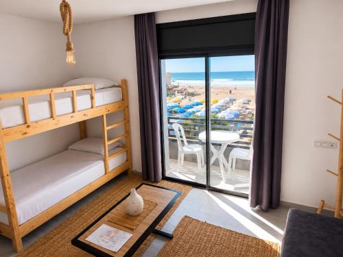 a bedroom with bunk beds and a view of the beach at Miramar Surf Anza in Agadir