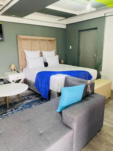 a bedroom with a large bed and a couch at R&N Hosts Mokhotlong in Mokoeng