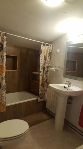 a bathroom with a toilet and a sink and a tub at El Mijares in Olba