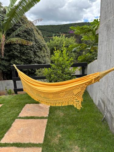 a hammock sitting on the grass in a garden at Chalé Aconchego in Caparaó Velho