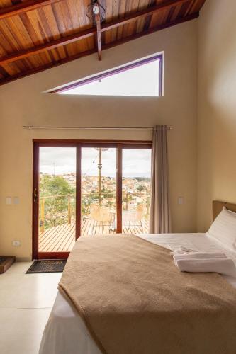 a bedroom with a bed and a large window at Refúgio das Serras in Cunha