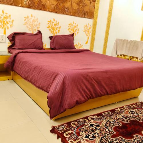 a bedroom with a large bed with red sheets and pillows at Adory homes inn in Kelambākkam