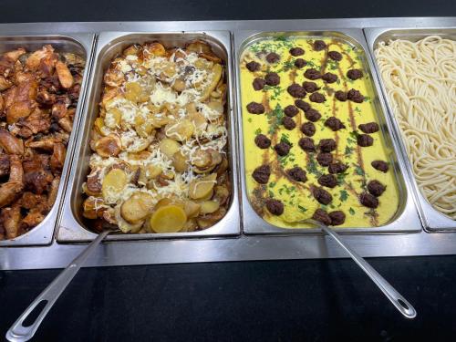 a row of trays filled with different types of food at Deluxe Suites ALL Inclusive in Sunny Beach