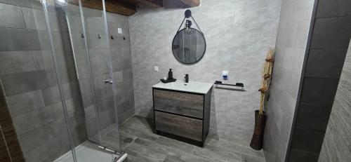 a bathroom with a sink and a shower and a mirror at El rincon de Fausto in Mudrián