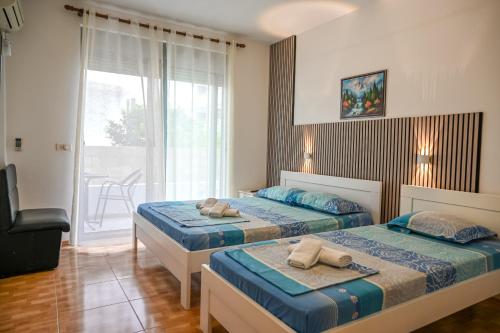 a bedroom with two beds and a balcony at Apartman Amin&Amina in Ulcinj