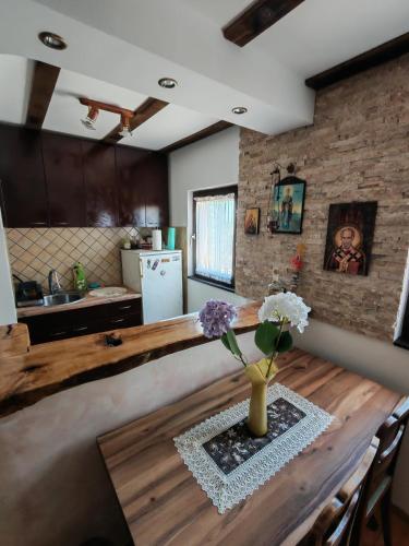 a kitchen with a wooden table with a vase of flowers on it at Dedinje, ul Zorana Mitrovića 22 in Jagodina