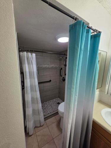 a bathroom with a shower with a toilet and a sink at Waikiki Vacation Apartment in Honolulu