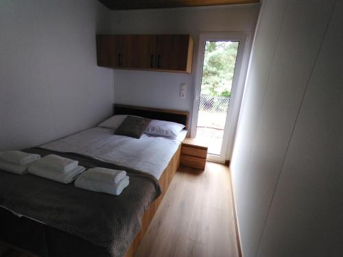 a small bedroom with a bed and a window at Domki nad Grabią in Rokitnica