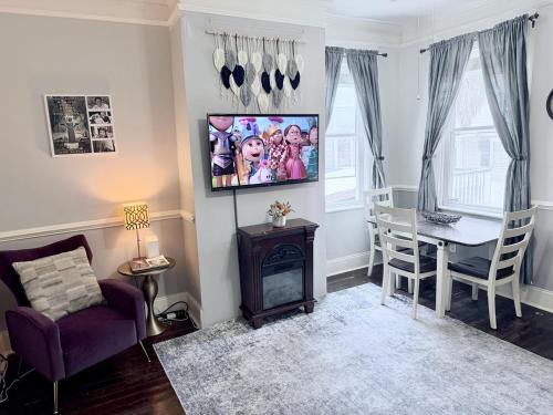 a living room with a table and a tv on the wall at Historic Savannah Condo, Sleeps 6, Pool, Dogs Ok in Savannah
