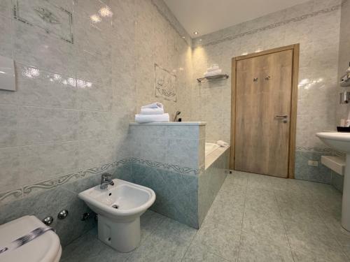 a bathroom with a sink and a toilet and a bidet at Hotel Angi in Fossò
