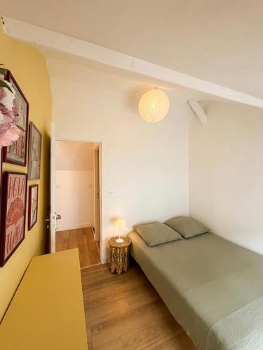 a bedroom with two beds and a table and a lamp at Au Canon - Parking gratuit - Bords de Loire in Orléans