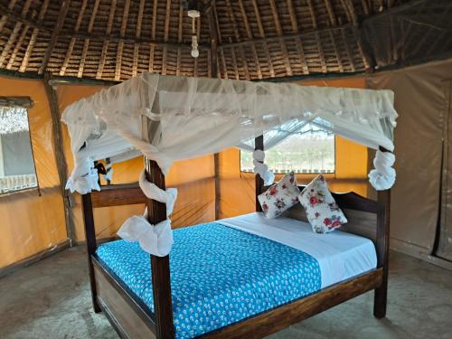 a bedroom with a bed with a canopy at Tausa Tsavo Eco Lodge in Voi