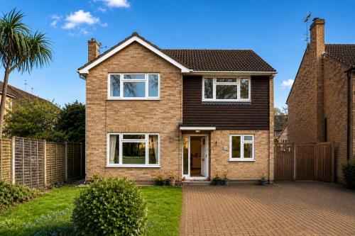 a brick house with a fence and a driveway at Farnborough Stay - 5 Bedrooms in Farnborough