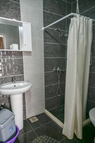 a bathroom with a shower curtain and a sink at Apartman Amin&Amina in Ulcinj