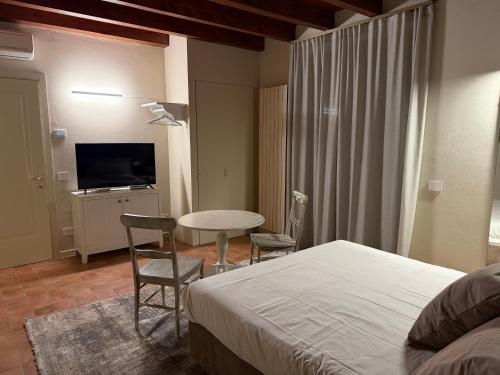 a bedroom with a bed and a table and chairs at La Quiete di Rivalta in Rivalta Trebbia