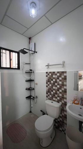 a bathroom with a toilet and a sink at Thad Transient House - Gensan in General Santos