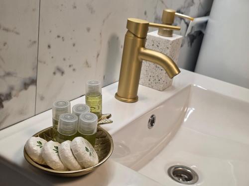 a bathroom sink with a gold faucet and a plate of food at Api Chalet in Avrig