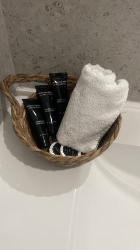 a basket on top of a toilet with towels at Versailles Rooms in Dukati i Ri