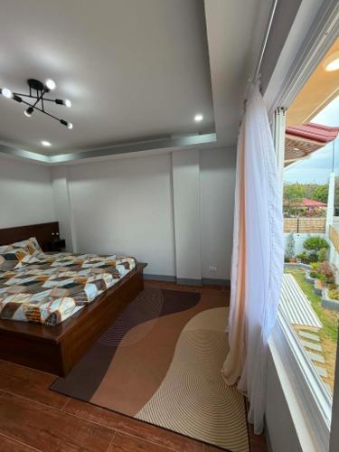 a bedroom with a bed and a window at Zensole Resort in Tarlac