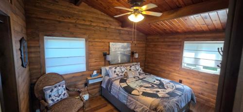 a bedroom with a bed and a ceiling fan at Captain JaC's Hideaway in Mallorytown