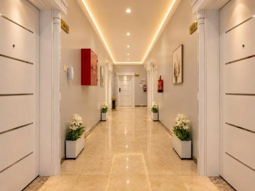 a hallway with potted plants in a building at توارن للشقق المخدومة - اقتصادي in Hail