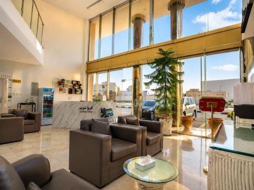 a living room with couches and a large window at توارن للشقق المخدومة - اقتصادي in Hail