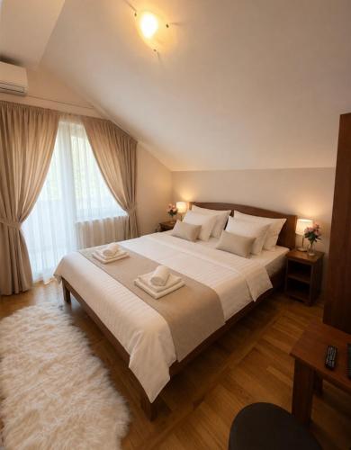 a bedroom with a large bed with white sheets and pillows at Balkan 024 in Subotica