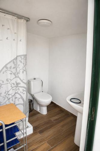 a white bathroom with a toilet and a sink at CALMA TIPI Glamping con piscina en Chiclana in Chiclana de la Frontera