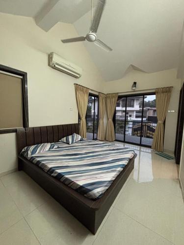 a bed in a bedroom with a ceiling fan at Cinnamon Villa - The Dream Stays ll Pvt Pool ll 3Ac Rooms ll Wi-Fi in Khandāla
