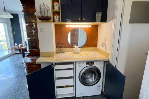 a kitchen with a washing machine in a room at Stunning View Seaside 1-Bed Apartment in Saronida in Saronida