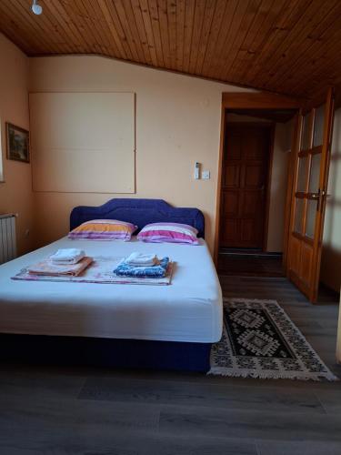 a bedroom with a blue bed with towels on it at Apartman Mickey in Sarajevo