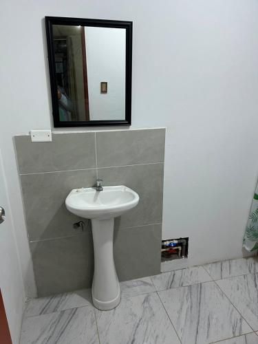 a bathroom with a sink and a mirror on the wall at Las Lomas Hotel in Caraz