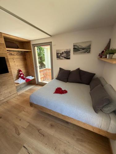a bedroom with a large bed with red flowers on it at Lidia & Orfeo in Bormio