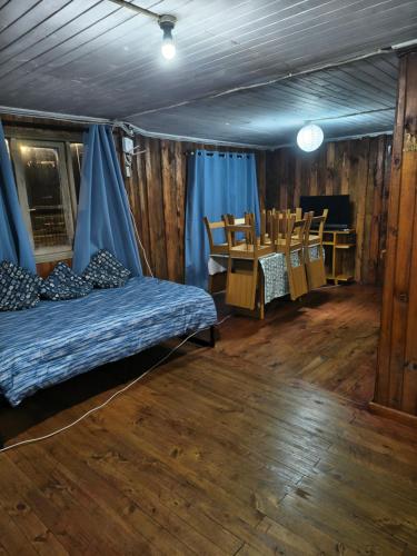 a room with a bed and a table and chairs at MiraMar Casa Azul in Puerto Saavedra