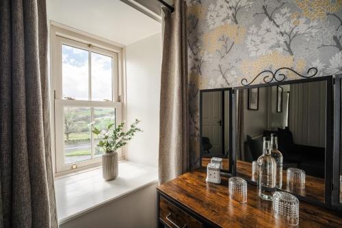 a dressing room with a mirror and a window at Redesdale Arms in Otterburn